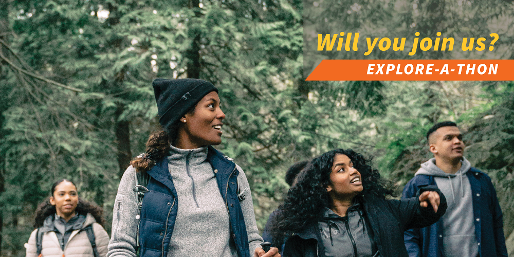 Four young people of color walking through the woods, smiling and looking up. The text reads "Will you join us? Explore-a-thon"