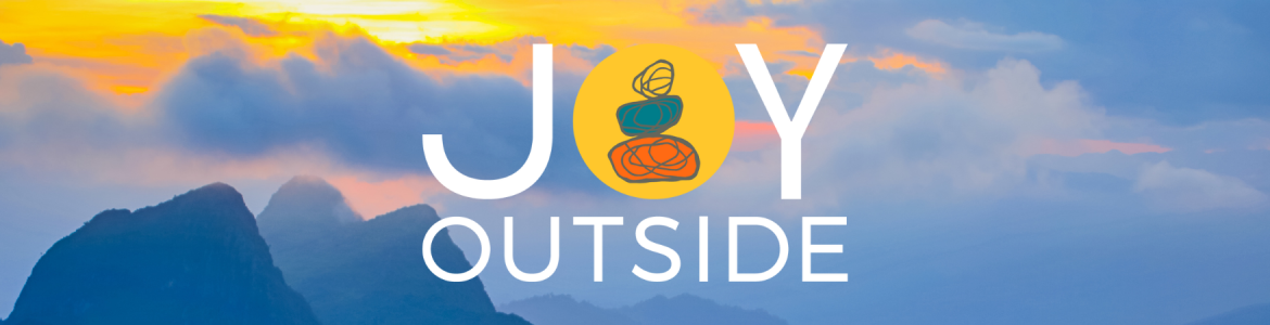 On a background image featuring blue hills during sunset, the Joy Outside logo is prominently featured. The text of the logo is white with the exception of the letter O which is a yellow circle. Inside the circle three rocks, orange, blue, and teal, can be seen stacked on top of one another.